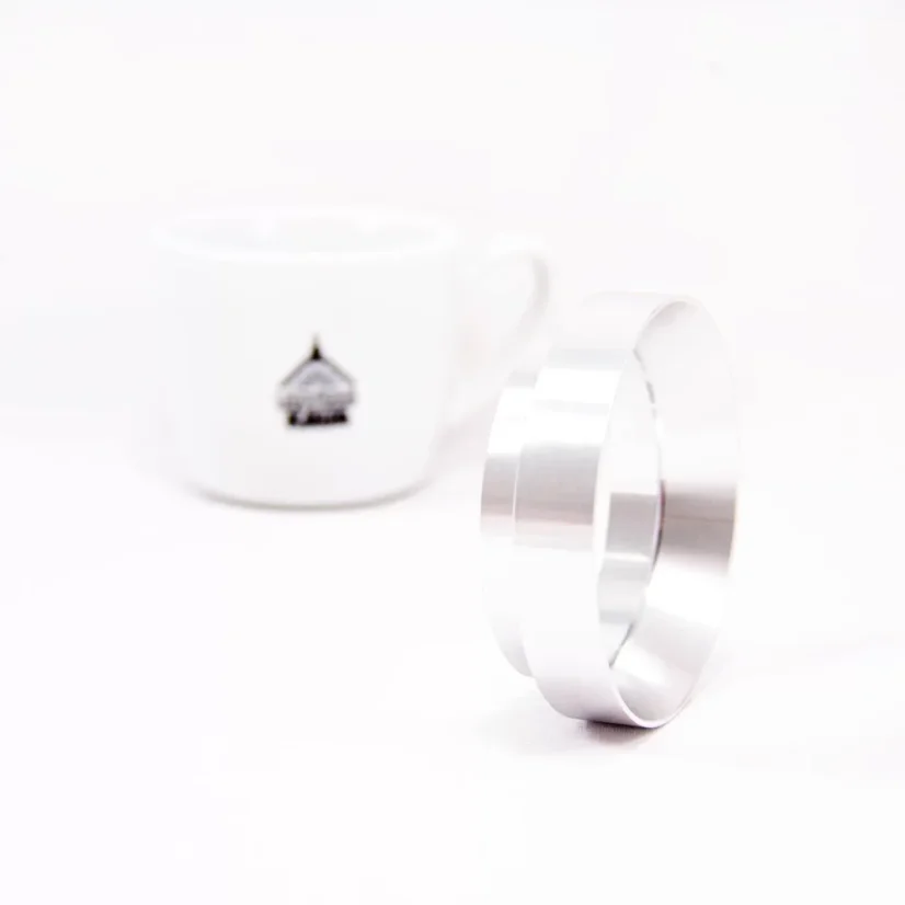Silver filling funnel 58 mm resting on the edge on a white background with a cup;