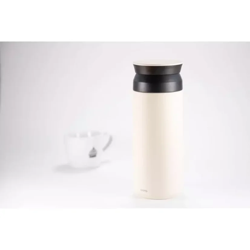 Gourde thermique en acier inoxydable blanc de 500 ml sur un fond blanc avec une tasse de café.