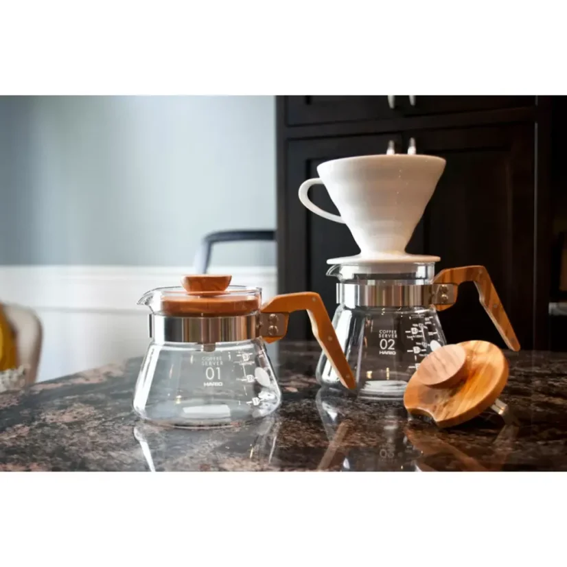 The 600 ml Hario Coffee Server in transparent colour is an elegant coffee pot made of glass with olive wood accents.