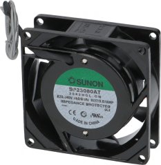 Schwaarzen quadratesche Axialventilator Sunon mat engem Metallgitter an engem gréngen Etikett, d'Uschlossdraiten zu engem Rank opgerollt.