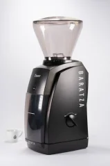 Black electric Baratza Encore grinder with a cup of coffee. Black electric Baratza Encore grinder with a cup of coffee.