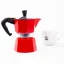 Moka pot by Bialetti from behind, next to a cup of coffee.