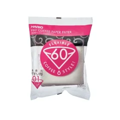 Białe papierowe filtry do V60 w kolorowym opakowaniu na jasnym tle