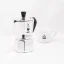 Silver Bialetti Moka Express pot for 2 cups on a white background with a cup of coffee, front view