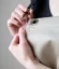 Tablier de barista beige, détail sur l'attache de la sangle. Tablier de barista beige, détail sur l'attache de la sangle.