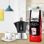 Bialetti New Moka Induction coffee maker next to a white cup and a package of coffee with the logo of the Italian brand Bialetti