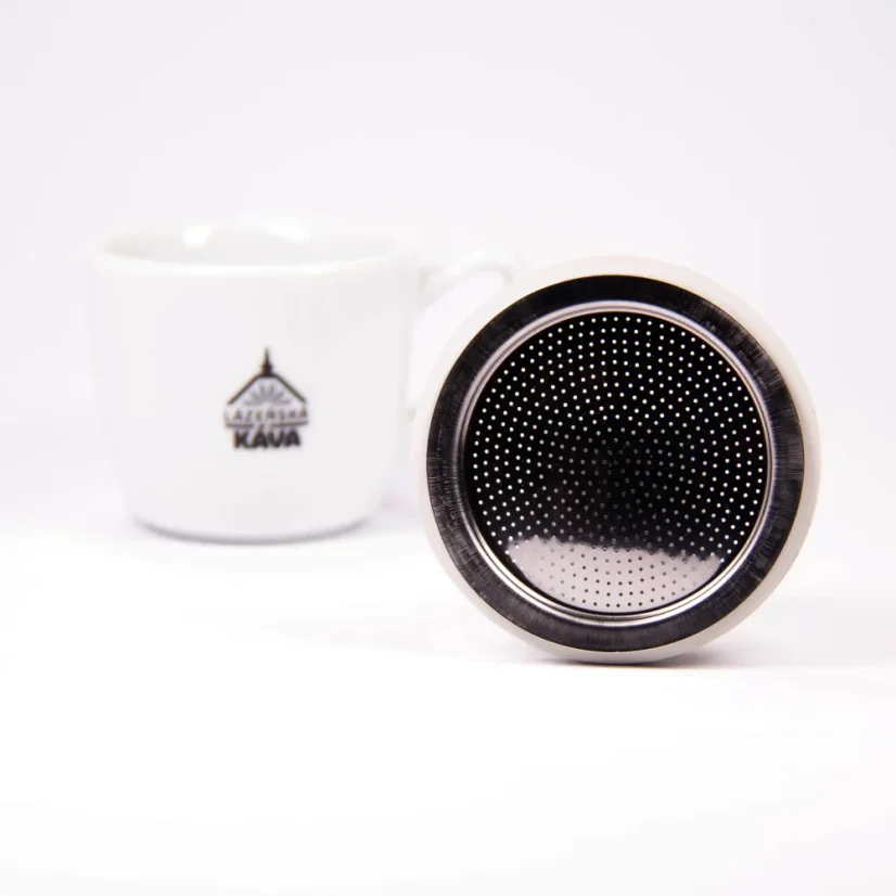 Espresso cup with a logo next to a spare gasket for a Bialetti moka pot.