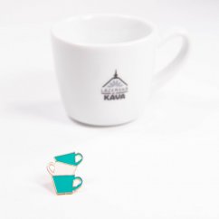 Taza azul con insignia Edo junto a la taza de café.