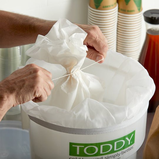 Tying the paper filter in the Toddy for the preparation of Cold Brew.