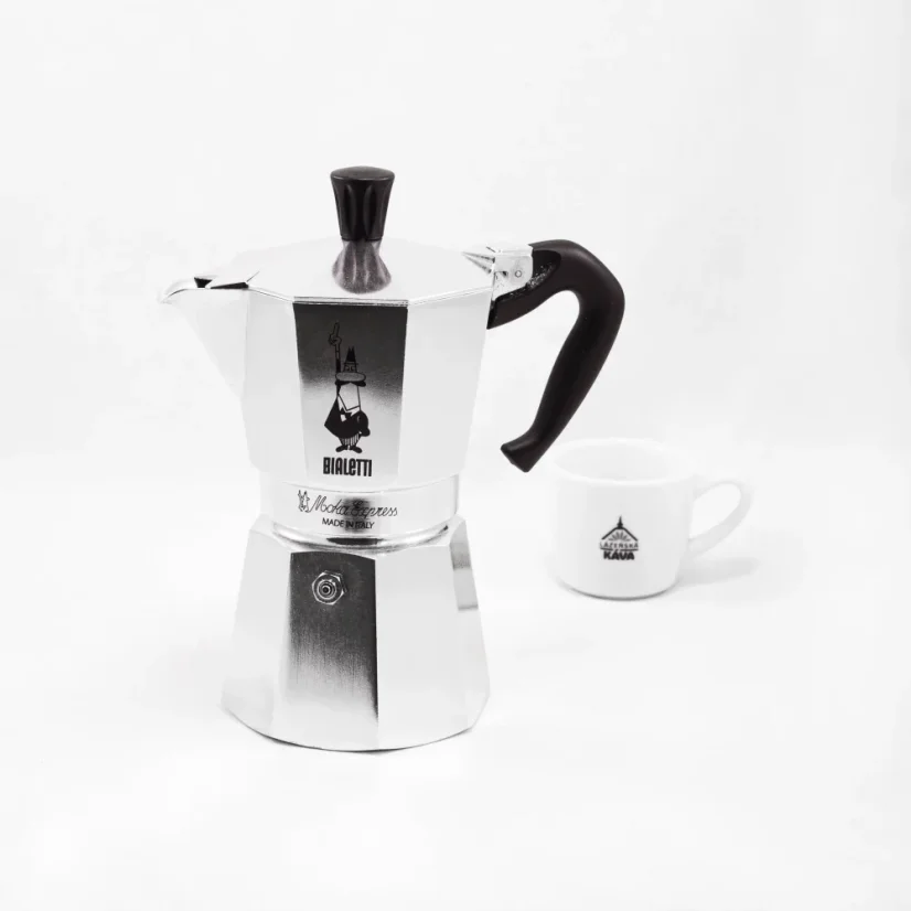 Moka-Kanne der italienischen Marke mit Bialetti Moka Express-Logo im Hintergrund mit einer Tasse im Vordergrund.
