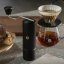 A black Timemore X Lite grinder next to the coffee server and dripper.
