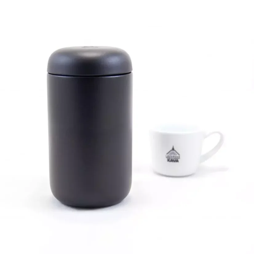 Insulated mug viewed from the front with coffee in the background.