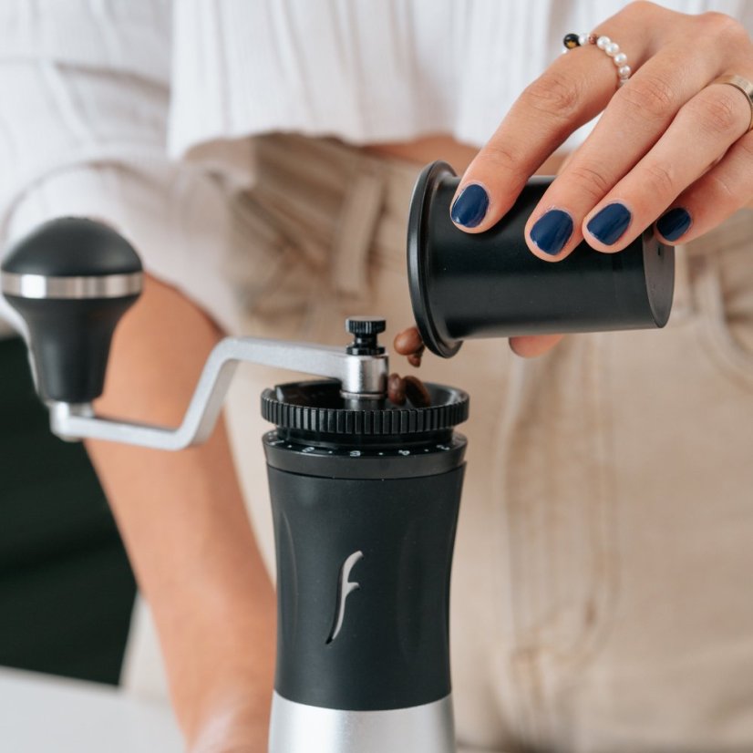 Pouring coffee beans into a Flair Royal grinder.