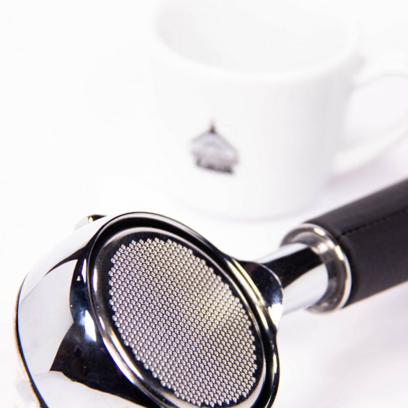 Detail nahého portafiltru Victoria Arduino s koženou rukoväťou s kúpeľnou kávou.