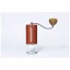 Hand-operated Comandante grinder in red color.