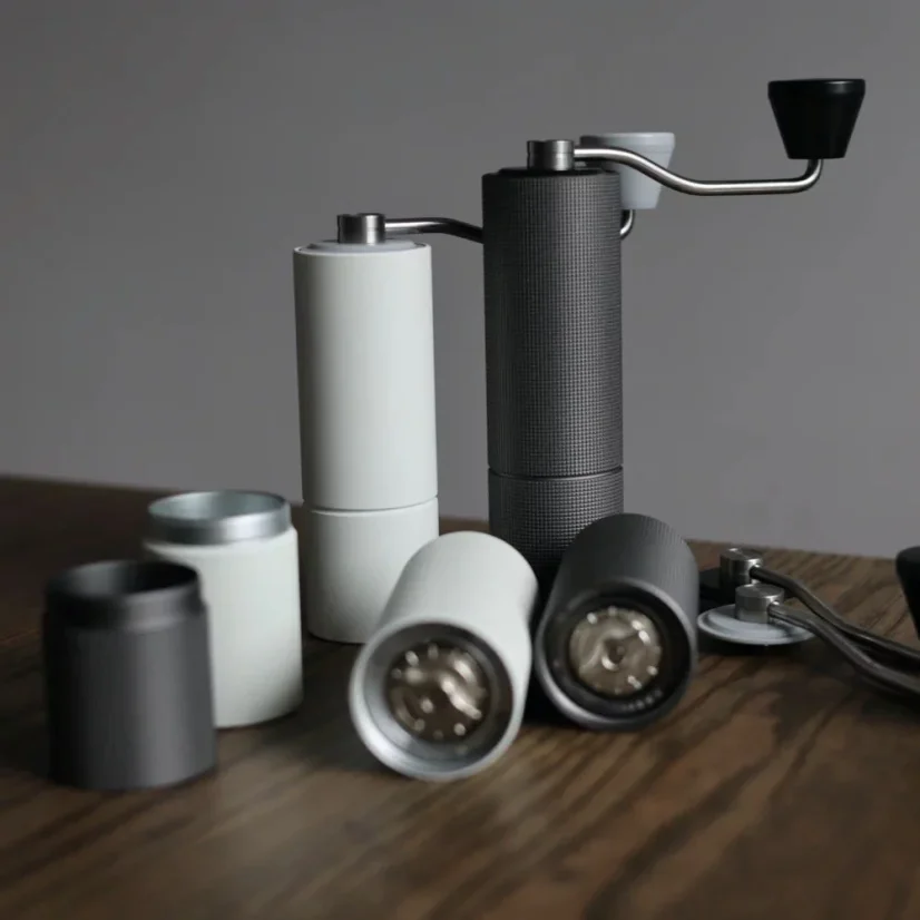 Biely a čierny mlynček Timemore Chestnut C2 Max pre ručné mletie kávy.