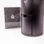 Detail na elektrický mlynček na kávu značky Wilfa Uniform WSFBS-100B spolu s čiernym balíčkom s motívmi.