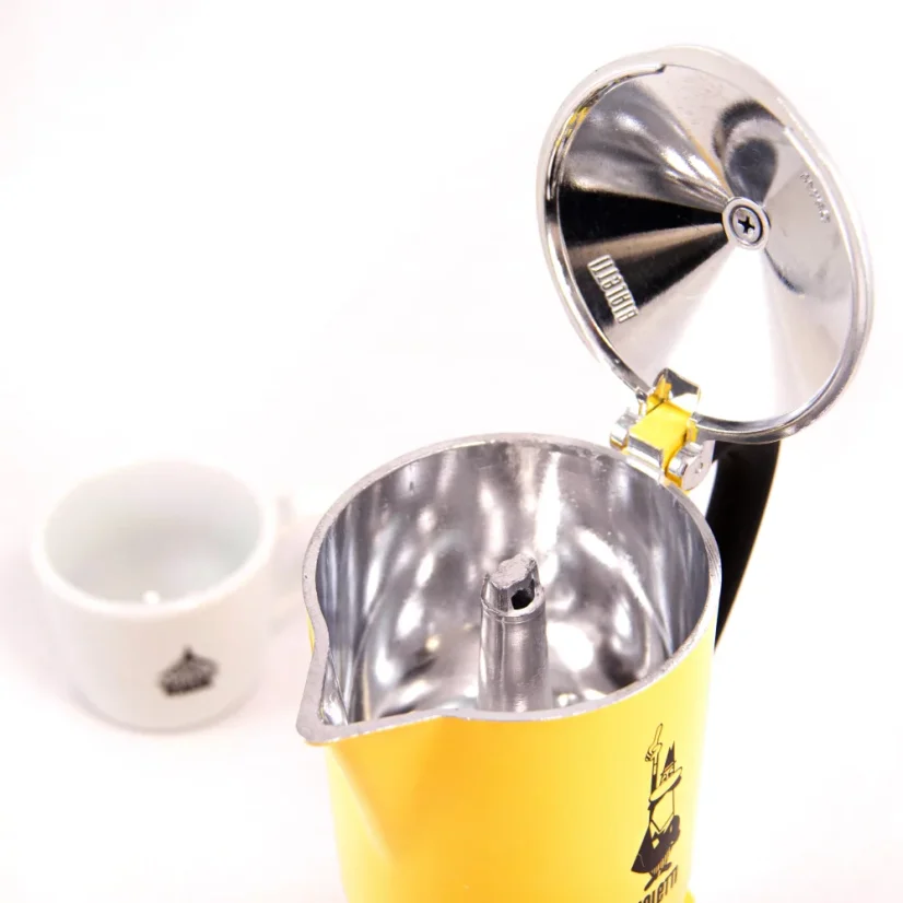 Cafetière Moka Bialetti Rainbow 6 ouverte de couleur jaune avec du café en arrière-plan.
