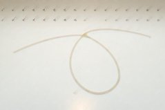 Dënnt, duerchsiichtegt PTFE-Schläichelchen mat klengem Duerchmiesser, lues an enger Schleef opgerollt. Dënnt, duerchsiichtegt PTFE-Schläichelchen mat klengem Duerchmiesser, lues an enger Schleef opgerollt.