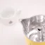 Détail du bec de la cafetière avec du café en arrière-plan.