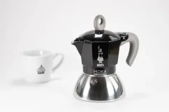 Moka en aluminium adaptée à l'induction avec le logo du fabricant - l'entreprise italienne Bialetti, en composition avec une tasse.