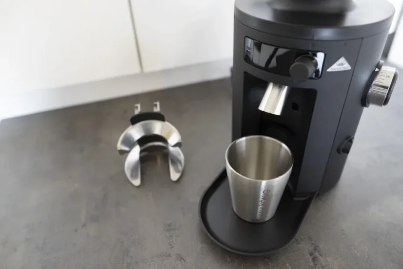 Black Mahlkonig X54 with a coffee dispenser and mounting.
