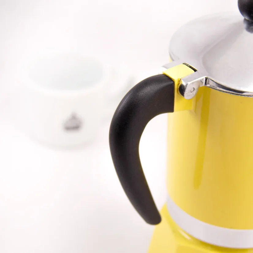 Détail sur la poignée de la cafetière avec café en arrière-plan