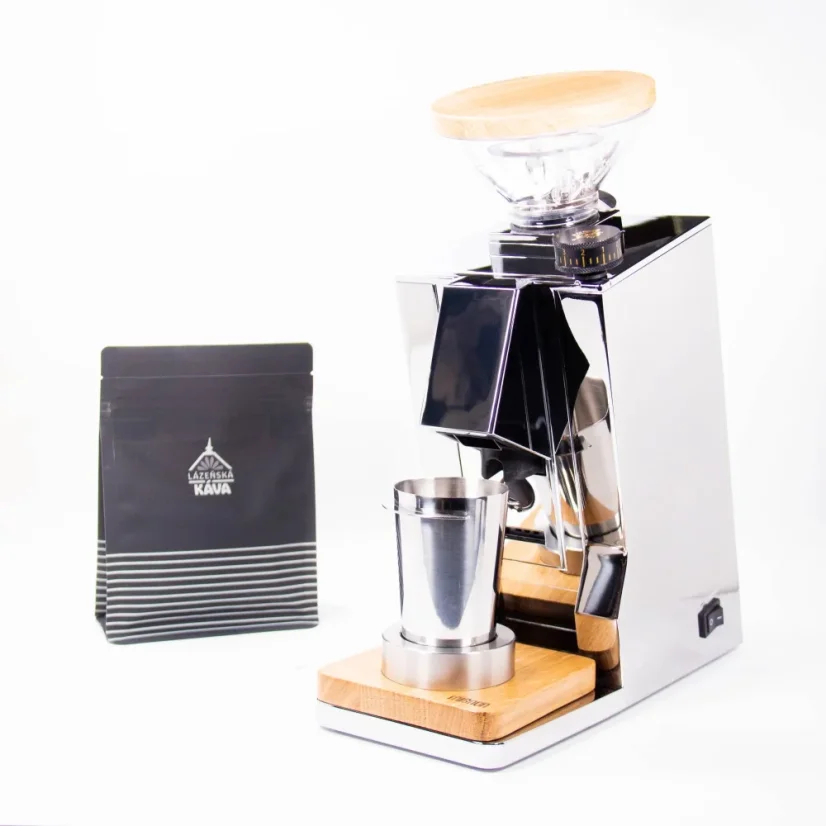 Paquet de café, à droite un moulin électrique argenté de marque Euureka.