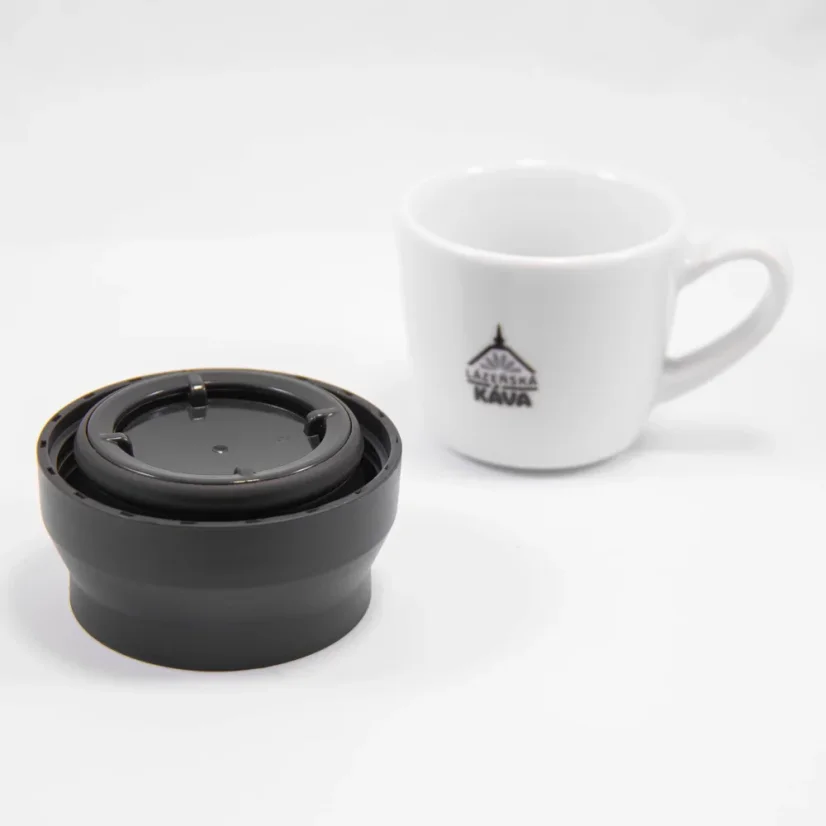 Deckel der Kinto Thermosflasche auf weißem Hintergrund mit einer Tasse Kaffee