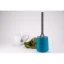 Grey plastic strainer with a blue holder and a porcelain cup with a plant in the background.