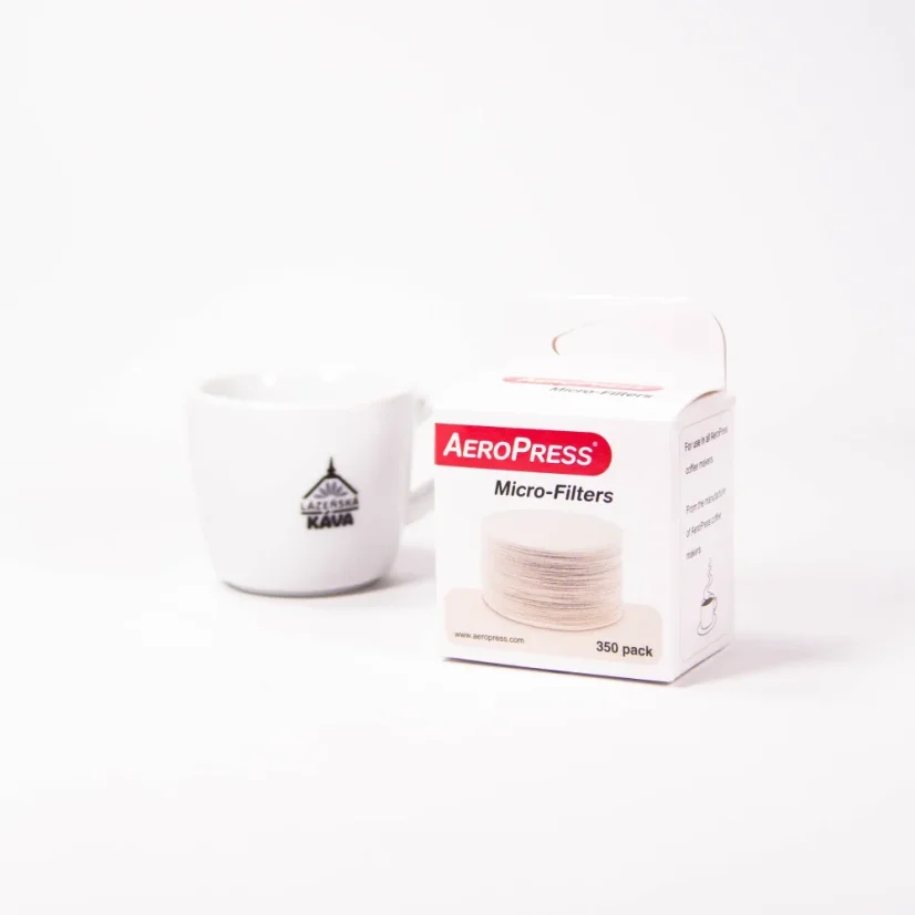 Filter für Aeropress in Originalverpackung auf weißem Hintergrund mit einer Tasse Kaffee.