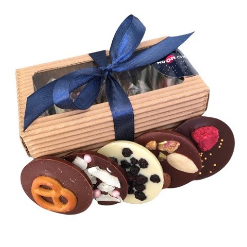 Emballage cadeau comprenant un nœud et divers chocolats.