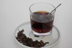 Cascara im Glas mit einem Löffel auf der Untertasse.