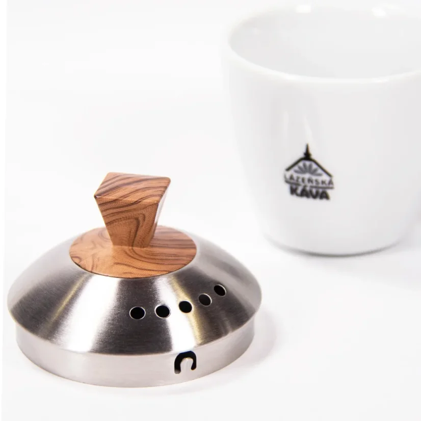 Silver electric kettle lid with a wooden handle on a white background with a cup of coffee