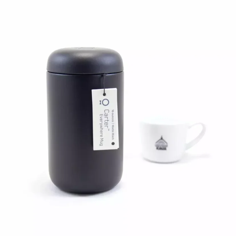 Thermal mug from the back with coffee in the background
