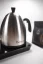 Brewista Smart Pour silberne elektrische Kanne vor einem Hintergrund mit einem Paket Kaffee