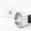 Detail des Idroprep Tampers von der Seite mit Kaffee im Hintergrund.