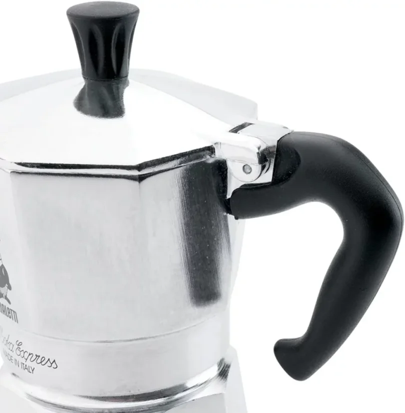 Silver Bialetti Moka Express pot for 3 cups on a white background, detail on the black handle of the pot