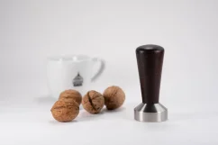 Top Wenge Heavy Tamper mit Nüssen und einer Tasse Kaffee