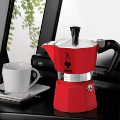 Bialetti Moka Express vedľa bielych servírovacích šálok.