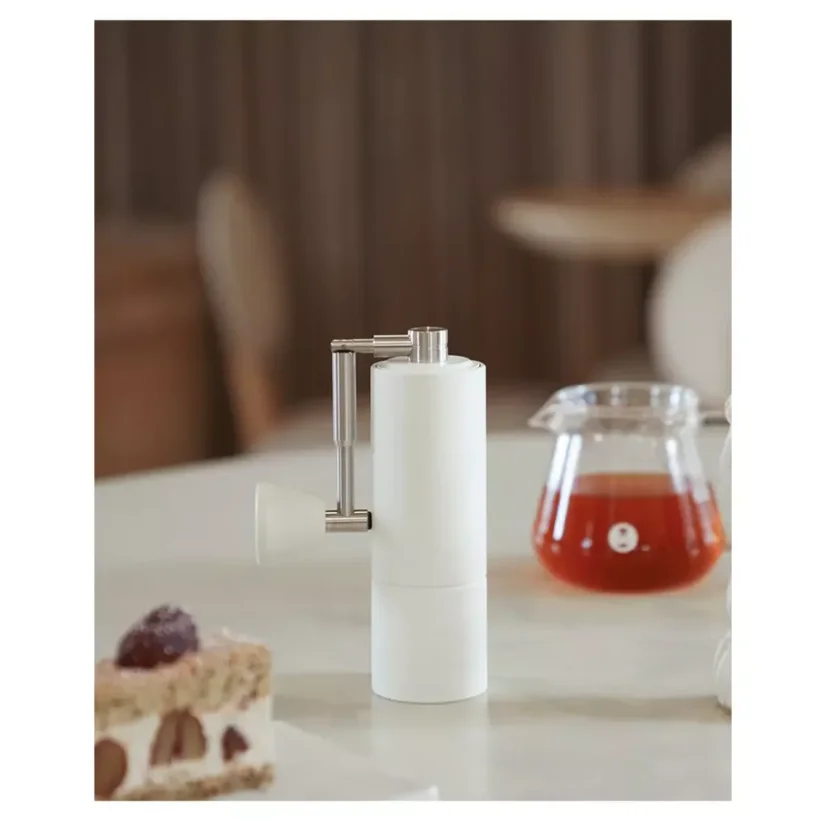 Le moulin à café manuel Timemore C2 est blanc, avec une poignée pliable pratique, idéal pour un usage domestique.