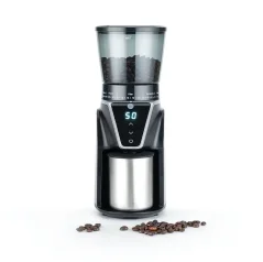 Silver electric coffee grinder by Wilfa with coffee beans in the foreground.