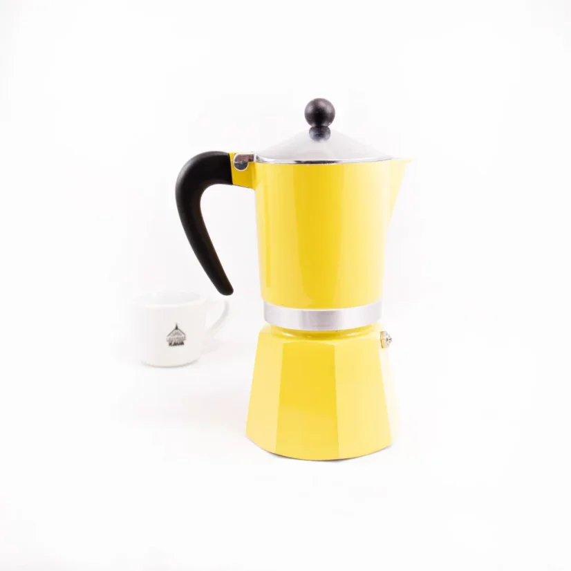 Bialetti Rainbow 6 in yellow from the back with coffee in the background.