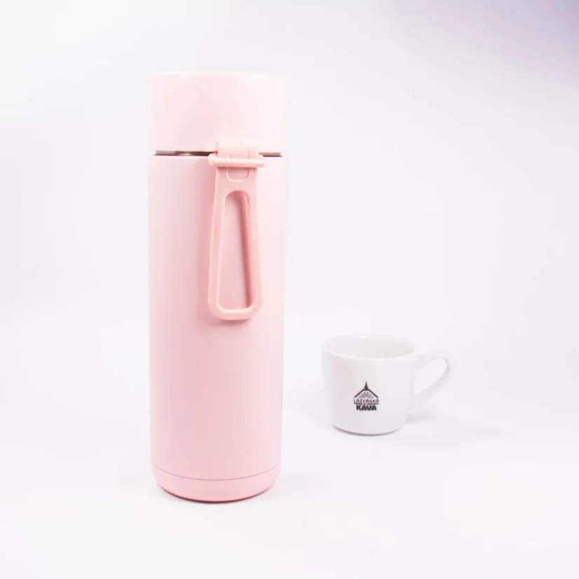 Ceramic thermos from the back with coffee in the background