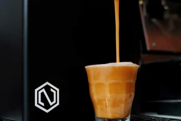 Stromend nitro cold brew koffie die in een glas wordt geschonken.