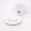 Viečko bielej elektrickej kanvice na bielom pozadí so šálkou kávy