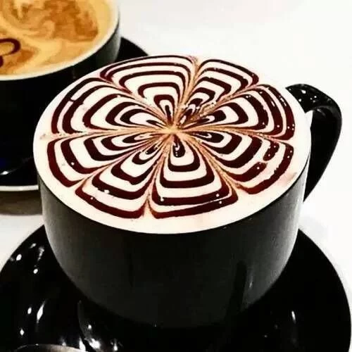 Détail de latte art dans une tasse noire.