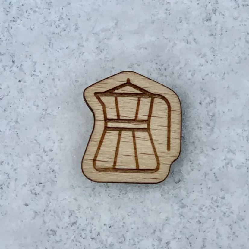 Holzabzeichen des Goldenen Kännchen-Ordens mit graviertem Kännchen-Symbol.