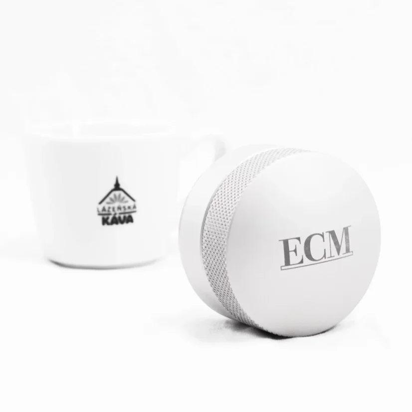 ECM coffee tamper with coffee in the background.