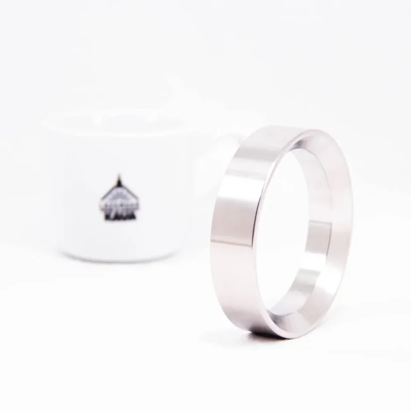 Náplňový lievik ECM s priemerom 58 mm s kávou v pozadí.